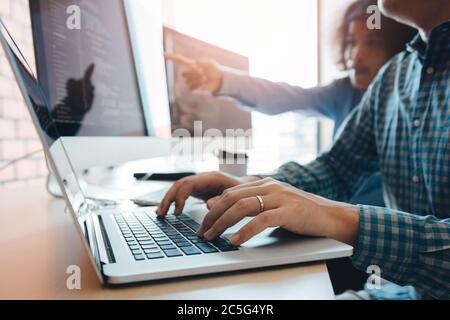 Two partnerships developing programming and coding technologies working on laptop and analyzing together. Stock Photo