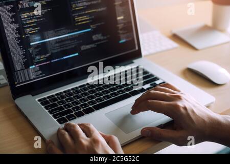 Close up hands of the software developers are sitting serious work analyzing data on the computer screen. Stock Photo