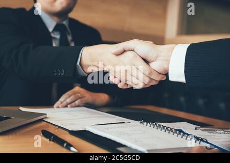Confident manager and employee people shaking hands with making a interview contract in the office. Stock Photo