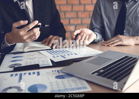 Businessman looking graph and summary report on document finance budget paper with analysis cost data result. Stock Photo