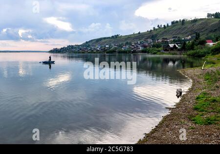 Ust-Kuda, Russia - 24 June 2020: Boy and girl catch fish from a boat in Angara river near rural russian village Stock Photo