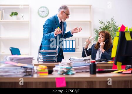 Two employees and excessive work in office Stock Photo