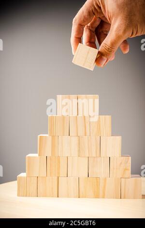 Wooden blocks arranged in stacks on grey background Stock Photo