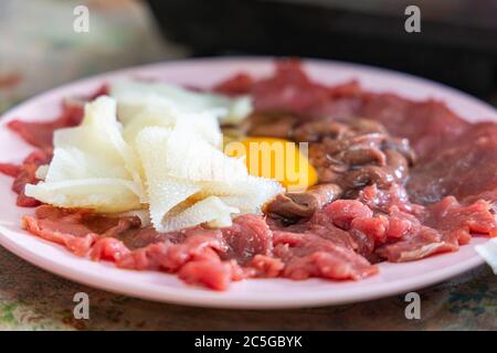 Cow giblets, fresh meat, liver and egg on plate. Meat set for soup. Stock Photo