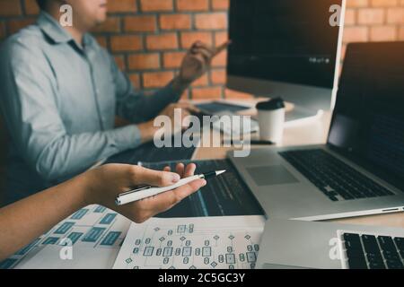 Two software developers are analyzing together about the code written into the program on the computer. Stock Photo
