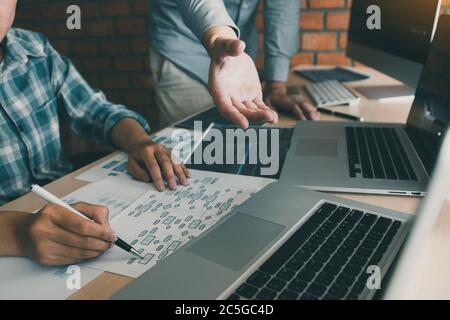 Two software developers are analyzing together about the code written into the program on the computer. Stock Photo