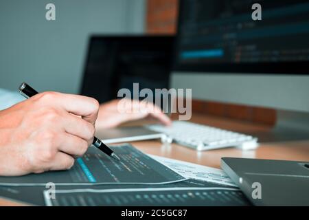People coding code program programming developer working design software on desk in office. Stock Photo