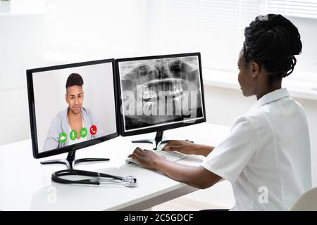 African Doctor In Video Conference Call Talking With Patient Stock Photo