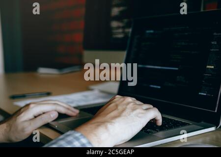 Close up hands of the software developers are sitting serious work analyzing data on the computer screen. Stock Photo