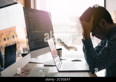 Software developers headache with code analysis in the office. Stock Photo
