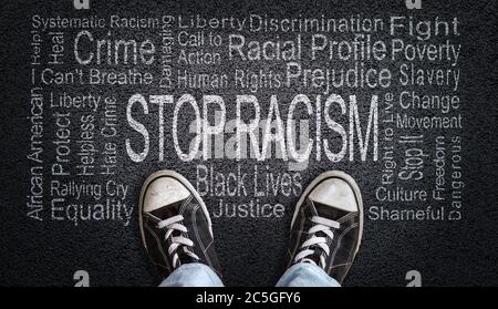 Person standing over Stop Racism word cloud. Concept of stopping discrimination against blacks or people of color because their lives matter. Stock Photo