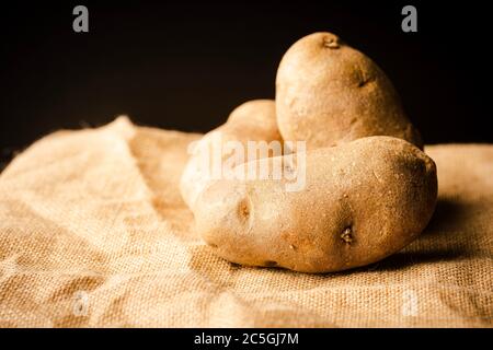 Fresh Potatoes on a rag with dark background Stock Photo - Alamy
