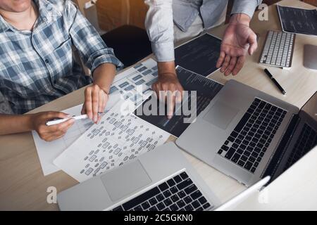 Two software developers are analyzing together about the code written into the program on the computer. Stock Photo