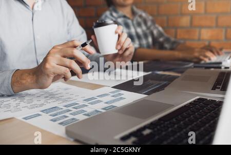 Working in the morning with businessmen are dipping coffee that works with software developers to analysis together the code written in the program on Stock Photo