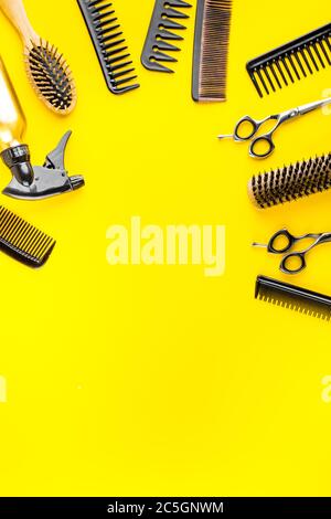Hairdressing instruments. Combs, scissors and spray on yellow desk from above frame space for text Stock Photo