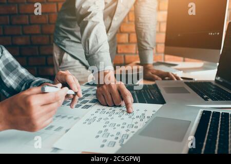 Two software developers are analyzing together about the code written into the program on the computer. Stock Photo