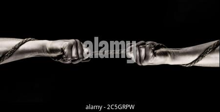 Rope, cord. Hand holding a rope, climbing rope, strength and determination concept. Safety. Macro shot isolated over black background Stock Photo