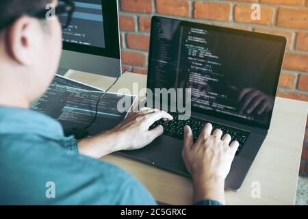 Two partnerships developing programming and coding technologies working on laptop and analyzing together. Stock Photo
