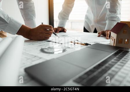 Engineering man showing blueprint detail for people buying house. Stock Photo