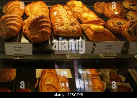 Assorted French pastry cake- Danish roll, scone, muffin and croissant displayed in glass showcase box Stock Photo