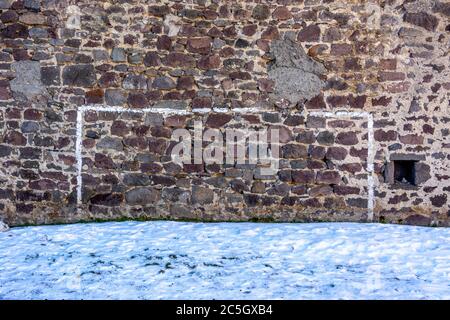 Painted football goal posts on a stone wall in winter, France Stock Photo