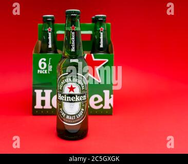 Sankt-Petersburg, Russia, Fenruary 02, 2020: Six pack of Heineken light lager beer on red background with one bottle on the foreground in focus studio Stock Photo