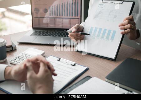Business employee man are reporting about performance graphs summary and financial budget calculations for managers in the office. Stock Photo