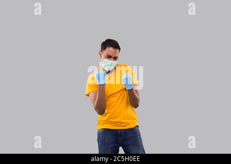 Indian Man Very Happy and Excited, Raising arms, Celebrating a Victory or Success Wearing Medical Mask and Gloves. Winner Sign. Indian man Isolated Stock Photo