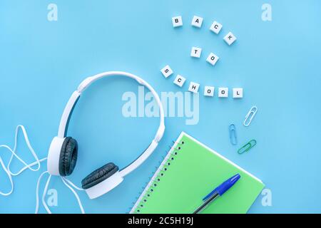 Back to school concept.Top view of school supplies with headphones with space for text on blue background. Stock Photo