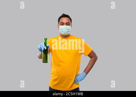 Indian man Holding Beer bottle Wearing Medical Mask and Gloves Isolated. Stock Photo