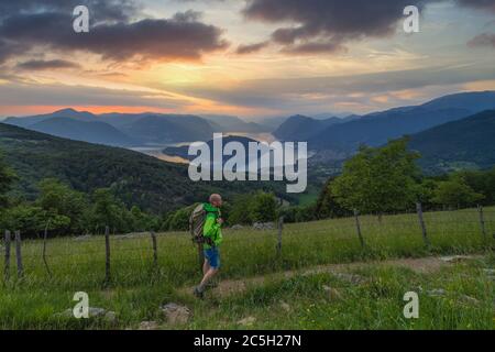 A man walks at Sunset over Iseo lake from Colmi di Polaveno, Polaveno, Brescia, Lombardy, Italy, Southern Europe Stock Photo