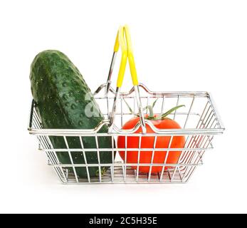 a small shopping basket with vegetables, tomato and cucumber on a white background. Healthy food, vegetarian food, vegetables, shopping at the superma Stock Photo