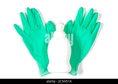 White plastic spray bottle on green rubber gloves isolated on background. Top view of alcohol liquid bottle and latex gloves on white background. Flat Stock Photo