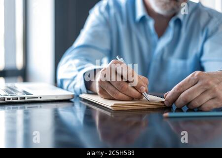 Businessman sitting in a business center restaurant, looking through documents. Stock Photo