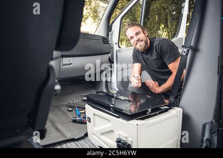 Happy man working inside his camper van Stock Photo