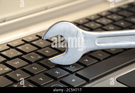 Wrench lying on keyboard symbolizing computer maintenance Stock Photo