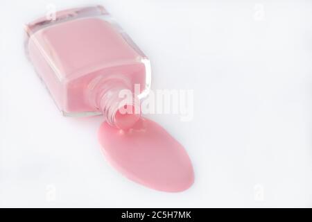 Spilled nail polish in a glass bottle on a white background, pink enamel for french manicure. Cosmetic product. Empty place for text. Copy space, mock Stock Photo