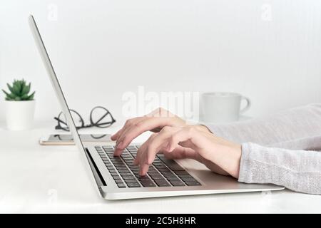 Unecognizable person typing on laptop keyboard, modern concept of office work or studying Stock Photo