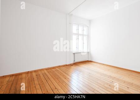 empty white room in apartment flat with hardwood floor and window Stock Photo