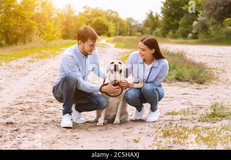 Portrait of happy young couple hugging their cute dog Stock Photo