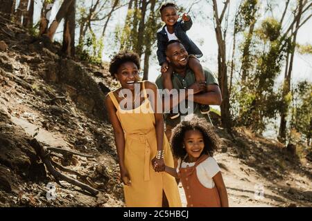 African family walking down a mountain trail. Young family enjoying their holidays in a national park. Stock Photo