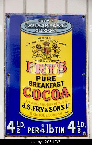 NR SOUTHAMPTON,UK - 25 June 2013: Old style tin advertising board for Fry's Cocoa displayed on painted wood background. On 25 June 2013 Near Southampt Stock Photo