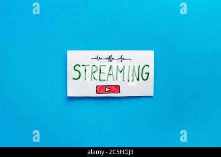 Live streaming concept - words on paper tablet on blue top view Stock Photo