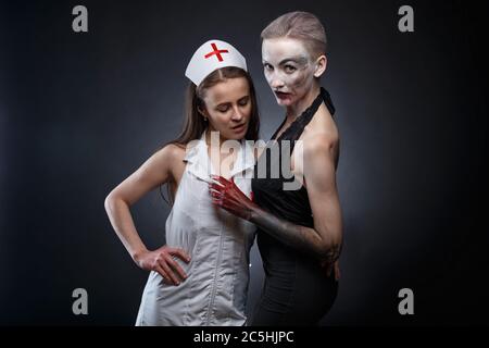 Photo of fake nurse hugging woman with blood hands Stock Photo