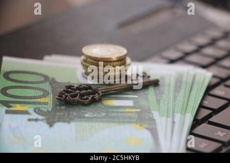 Computer keyboard with euro banknotes on it and vintage key. Key to success concept. Online business concept Stock Photo