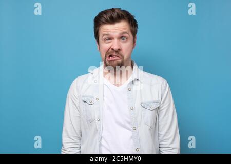 Crazy looking man making funny faces squinting eyes Stock Photo