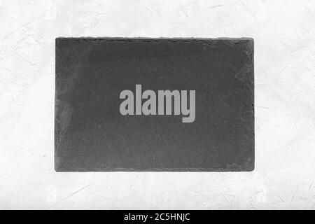 Empty Black slate Tray Plate isolated on white textured background. Top view Mock up Stock Photo