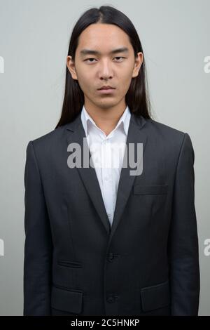 Young Asian businessman with long hair in suit Stock Photo