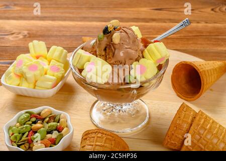 side view bowl of chocolate flavor ice cream with marshmallows and various nuts Stock Photo