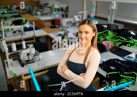 Portrait of a seamstress standing at working place and looking at camera Stock Photo